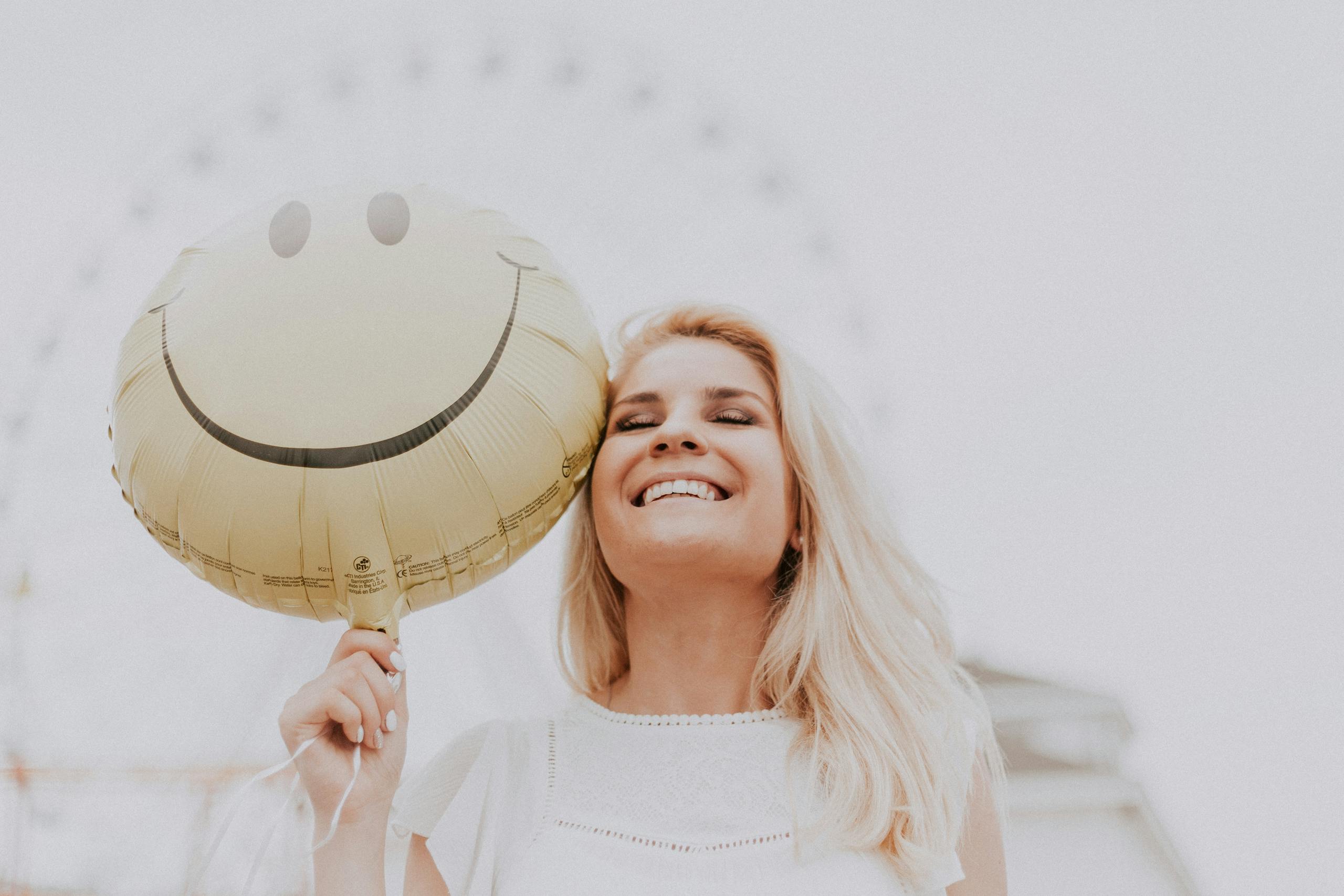 Image of a woman smiling and holding a balloon, symbolizing positive changes during life transitions